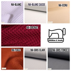 May include: A collection of waffle fabric swatches in various colors, including white, off-white, beige, red, orange, light gray, and dark gray. The fabric is textured and has a waffle-like pattern. The swatches are labeled with the color names in French.