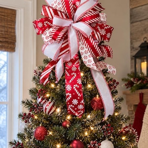 May include: A large Christmas tree topper bow featuring multiple ribbons in red and white. The design includes patterns of candy canes, peppermint swirls, and solid red and white stripes with glittery edges, cascading down the tree.