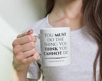 May include: White ceramic mug with black text that reads "You must do the thing you think you cannot do" - Eleanor Roosevelt.