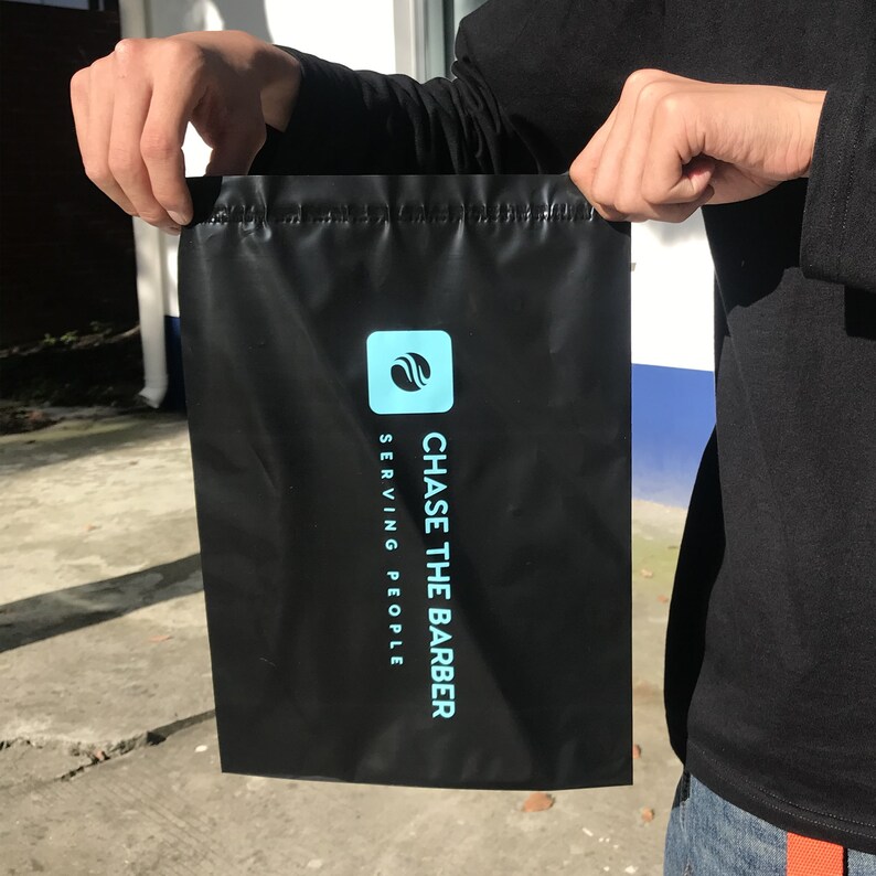 May include: Black drawstring bag with a blue logo that says "CHASE THE BARBER SERVING PEOPLE"