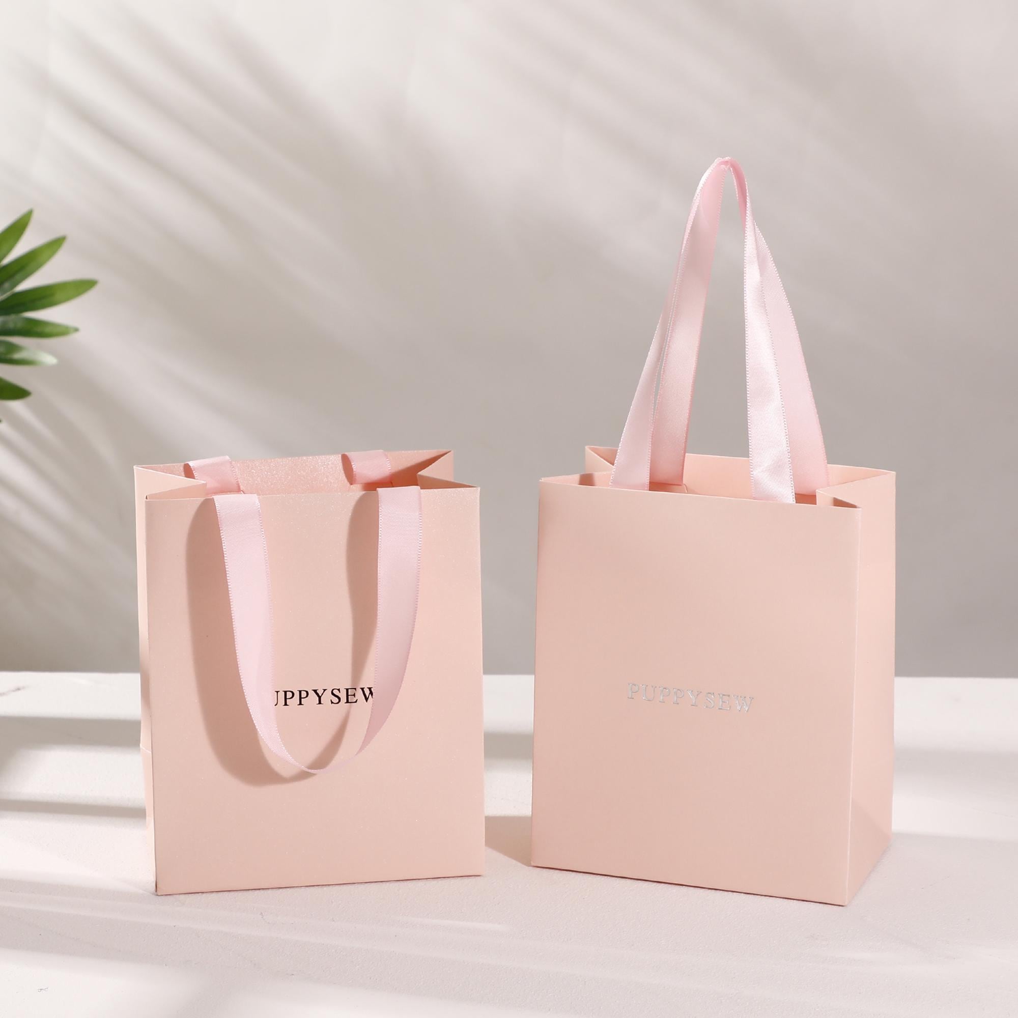 Bulk 50pcs pearlescent pink paper bags, showing stackable design for easy storage and low MOQ suitability