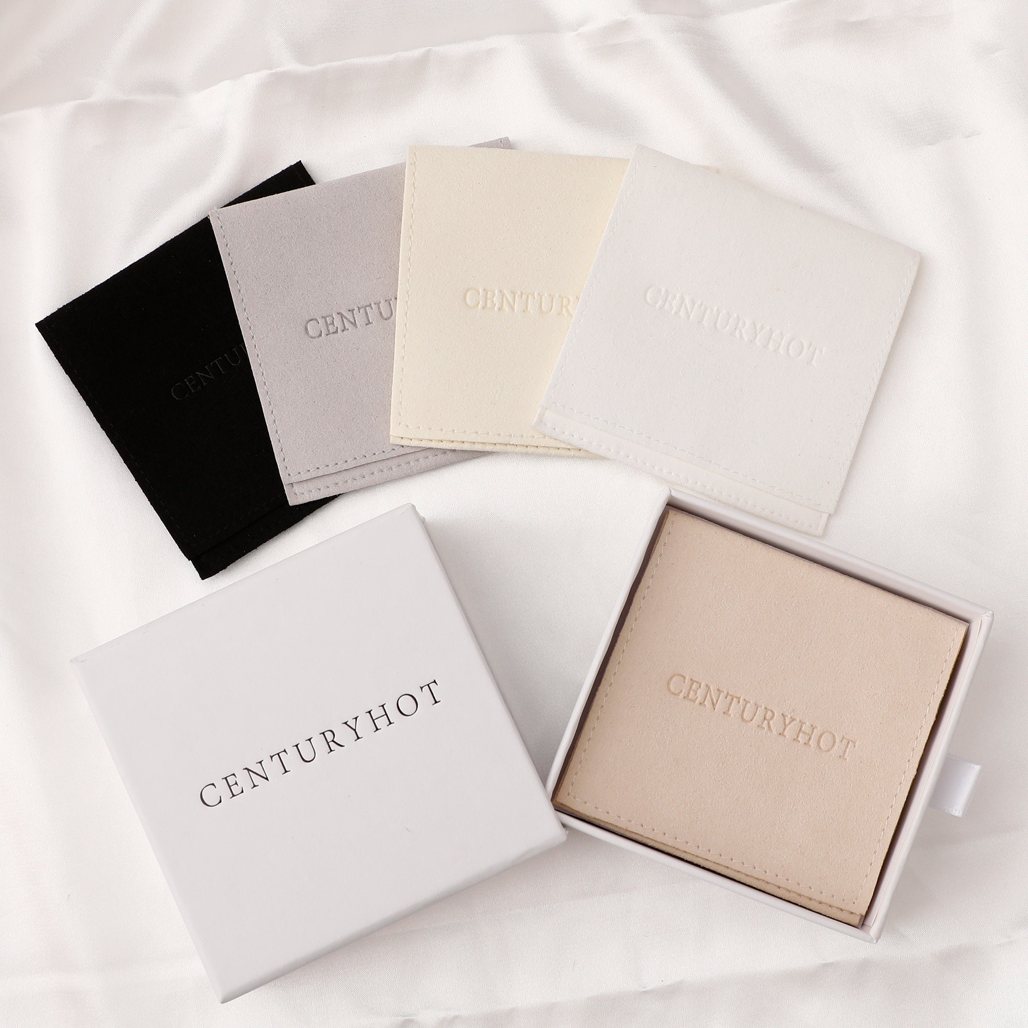 Bulk 50pcs ivory microfiber bags with size variety, ideal for small jewelry brands choosing packaging