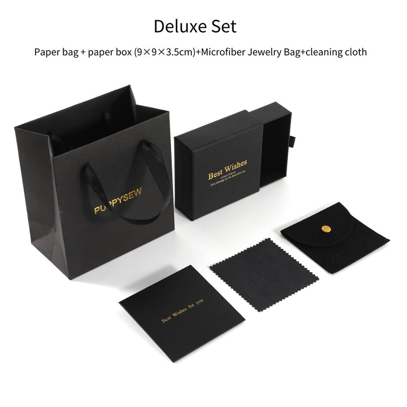 May include: A black gift box set with a black paper bag, a small black jewellery bag, a black cleaning cloth, and a black card with gold lettering that says "Best Wishes for you". The paper bag has a gold logo that says "PUPPYSEW". The gift box has a sliding lid and gold lettering that says "Best Wishes".