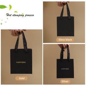 May include: Three black gift bags with black ribbon handles. The bags have the text "PUPPYSEW" printed in gold, silver, and gloss black.