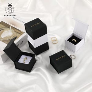 PUPPYSEW 6*6*3,5 cm Caja negra de papel texturizado Caja de joyería magnética de lujo con tapa Caja de cartón para collares, pulseras, anillos, collares y joyas Caja con logotipo