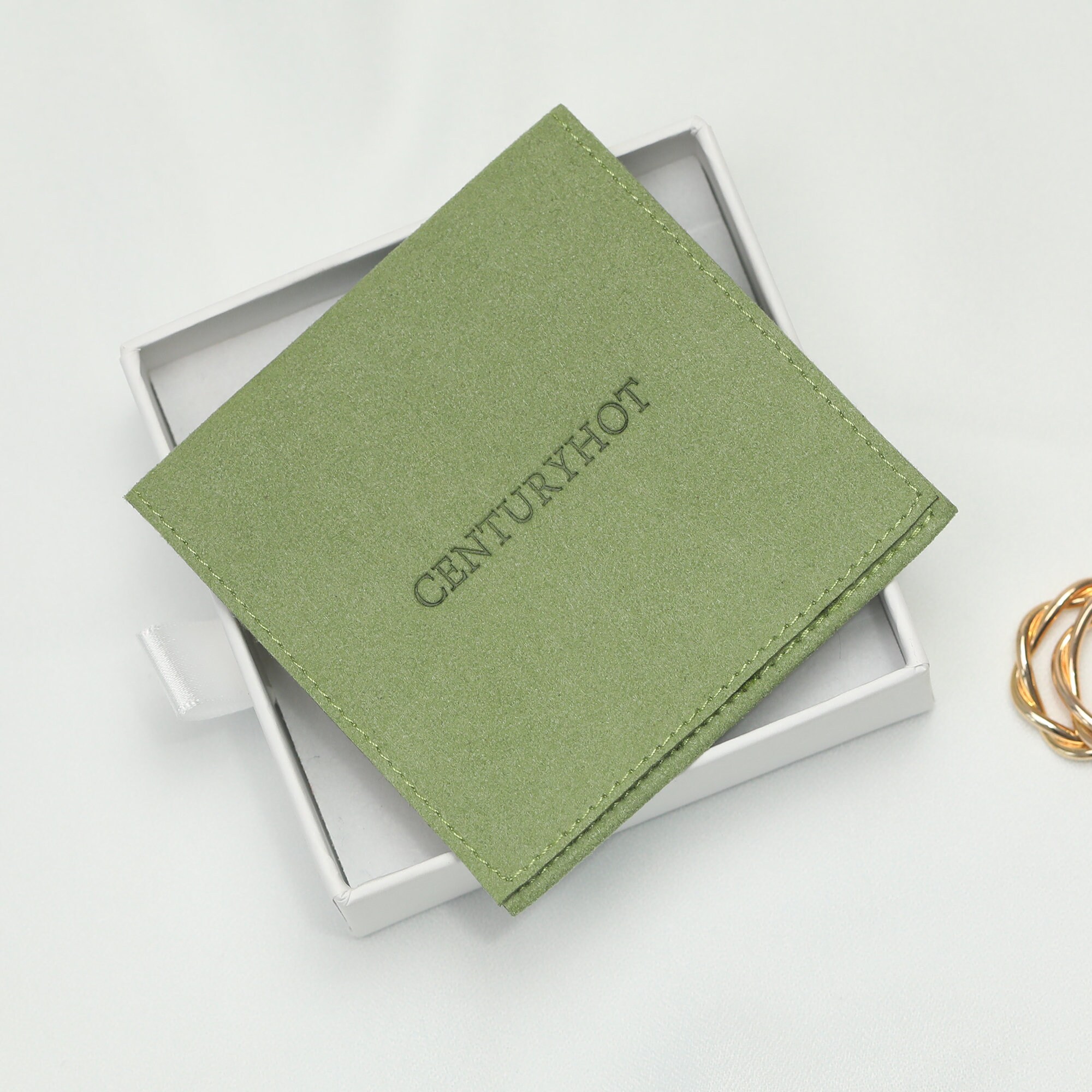 Grass green jewelry bags with embossed custom logo—proof of personalized packaging for brand consistency