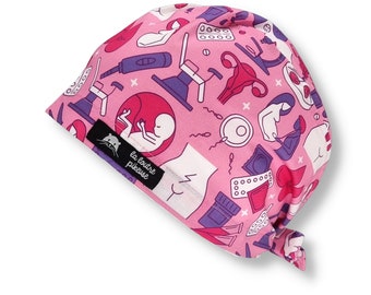May include: Pink surgical scrub hat with a pattern of medical illustrations, including a uterus, a fetus, a stethoscope, and pills. The hat has a tie at the back and a label that reads "la loutre pieuse".