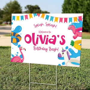 May include: A white yard sign with the text "Splish, Splash! Welcome to Olivia's Birthday Bash!" in pink and blue. The sign features illustrations of a flamingo, a unicorn float, and other pool-themed graphics. The sign is displayed on a green lawn.