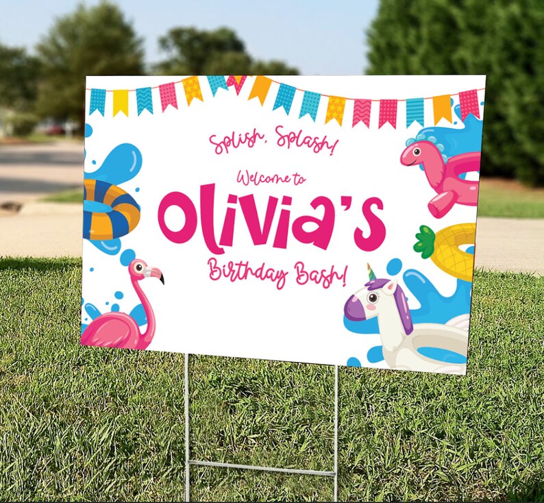 May include: A white yard sign with the text "Splish, Splash! Welcome to Olivia's Birthday Bash!" in pink and blue. The sign features illustrations of a flamingo, a unicorn float, and other pool-themed graphics. The sign is displayed on a green lawn.