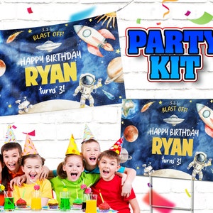 May include: A party kit featuring a blue and white banner and a sign with a space theme. The banner and sign read "Happy Birthday Ryan turns 3!" with a rocket, planets, and stars. 3-2-1 Blast Off! is written on both the banner and sign.