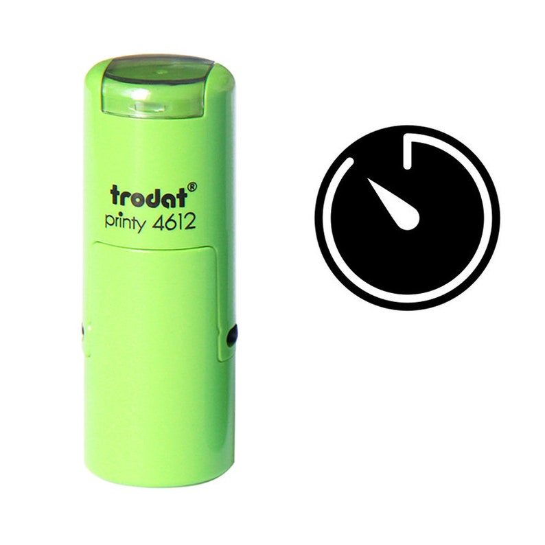 Pu&ograve; includere: Un timbro verde Trodat printy 4612 con un'icona di cronometro nera. Il timbro ha un design rettangolare con bordi arrotondati e un cappuccio trasparente. L'icona del cronometro &egrave; un cerchio nero con un contorno bianco e una lancetta bianca.