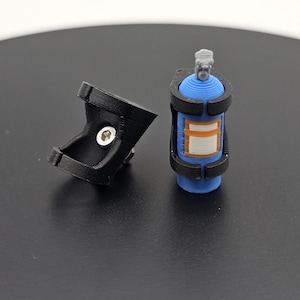 May include: A blue and orange spray can with a black bracket and a separate black bracket with a silver fastener. The spray can has a gray nozzle and a white and orange label.