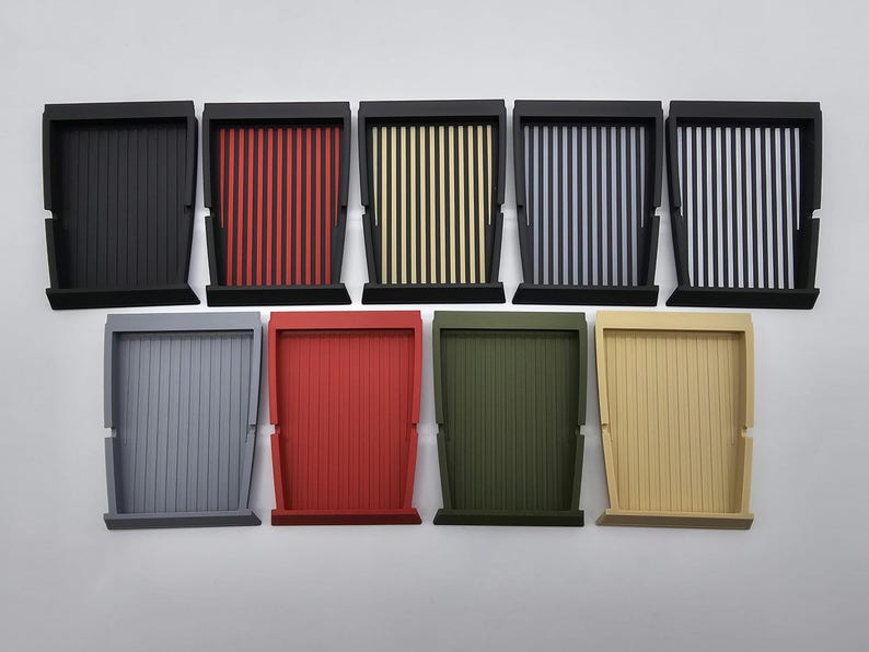 May include: A collection of ten wooden trays in various colors. The trays have a rectangular shape with vertical slats and a black frame. Colors include black, red, yellow, purple, gray, red, green, and beige.