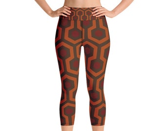 May include: Red and brown patterned yoga leggings with a high waist. The pattern is a geometric design with a repeating motif.