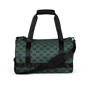 May include: A black duffel bag with a green and purple geometric pattern. The bag has two top handles and a shoulder strap.