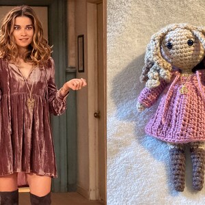 Può includere: Una bambola all'uncinetto con un vestito rosa e stivali marroni. La bambola ha i capelli lunghi e biondi e gli occhi marroni.
