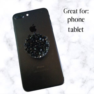 May include: Black phone case with a black rhinestone phone grip. The text "iPhone" is visible on the back of the case.  Great for: phone tablet