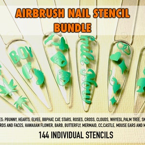 May include: A set of 144 individual nail stencils for airbrushing. The stencils are made of clear plastic and feature a variety of designs, including hearts, stars, flowers, and words. The stencils are arranged in a row on a white background.
