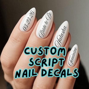 May include: White almond-shaped nail decals with black script text. The text includes a date, the phrase "Bride to Be", a name, and the word "Feminine". The image also displays the text "CUSTOM SCRIPT NAIL DECALS".