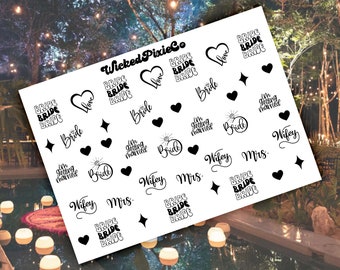 May include: A sheet of white nail stickers with various designs, including hearts, stars, rings, and the words "Bride", "Wifey", "Mrs.", "I'm getting married", and "Bride Bride Bride".