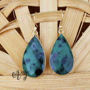 Peut inclure: Une paire de boucles d'oreilles en forme de goutte d'or avec des pierres précieuses vertes et noires.