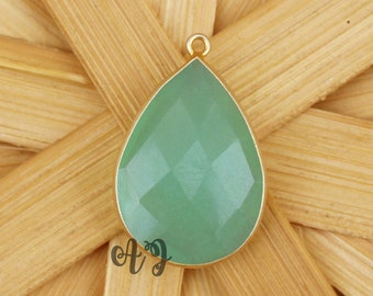 May include: A teardrop-shaped pendant with a light green gemstone set in gold.