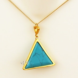 May include: A gold-colored necklace with a triangular pendant. The pendant features a turquoise stone set within a gold frame. The necklace chain is delicate and gold-colored, creating a simple yet elegant design.
