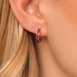 May include: Silver hoop earrings with a thin red enamel band.