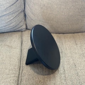 May include: A black wooden turntable stand with a round top and a rectangular base.