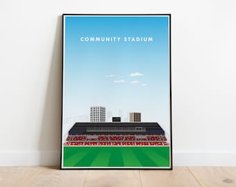May include: A minimalist illustration of a football stadium with red seats, a green pitch, and the text "COMMUNITY STADIUM" at the top. The stadium is set against a blue sky with white clouds.
