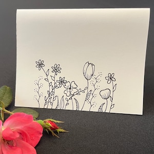 Puede incluir: Un dibujo en blanco y negro de un ramo de flores con un tulip&aacute;n, una amapola y otras flores silvestres.