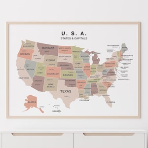 Könnte beinhalten: Eine gerahmte Karte der USA mit Bundesstaaten und Hauptstädten in neutralen Farbtönen. Die Karte hat einen hellen Holzrahmen. Die Karte wird über einer weißen Kommode angezeigt.
