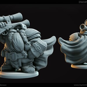 Peut inclure: Une miniature d'un ranger nain en plastique gris imprimé en 3D tenant un fusil avec une lunette. Le nain porte une cape et a une barbe. La miniature est sur une base ronde. "DWARVEN RANGER" est écrit dans le coin supérieur droit de l'image.