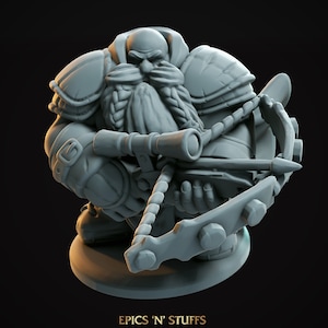 Puede incluir: Una figura en miniatura de plástico gris de un guerrero enano sosteniendo una ballesta. El enano lleva armadura y tiene una larga barba. La miniatura está sobre una base redonda.