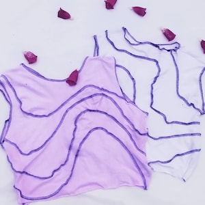 May include: Two sleeveless tops with a wavy, zig-zag stitch detail. One top is white and the other is light purple.