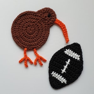 May include: Two crocheted felt ornaments, a brown kiwi bird with orange beak and legs, and a black and white football.