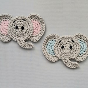 May include: Two handmade crochet elephant appliques. The elephants are grey with pink and blue inner ears and black eyes. The appliques are made of yarn and are suitable for various craft projects.