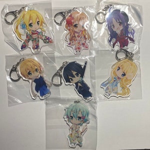May include: A collection of anime-style character keychains. Each keychain features a colorful illustration of a character with large eyes and unique outfits. The keychains are attached to silver-colored key rings and are packaged in clear plastic.