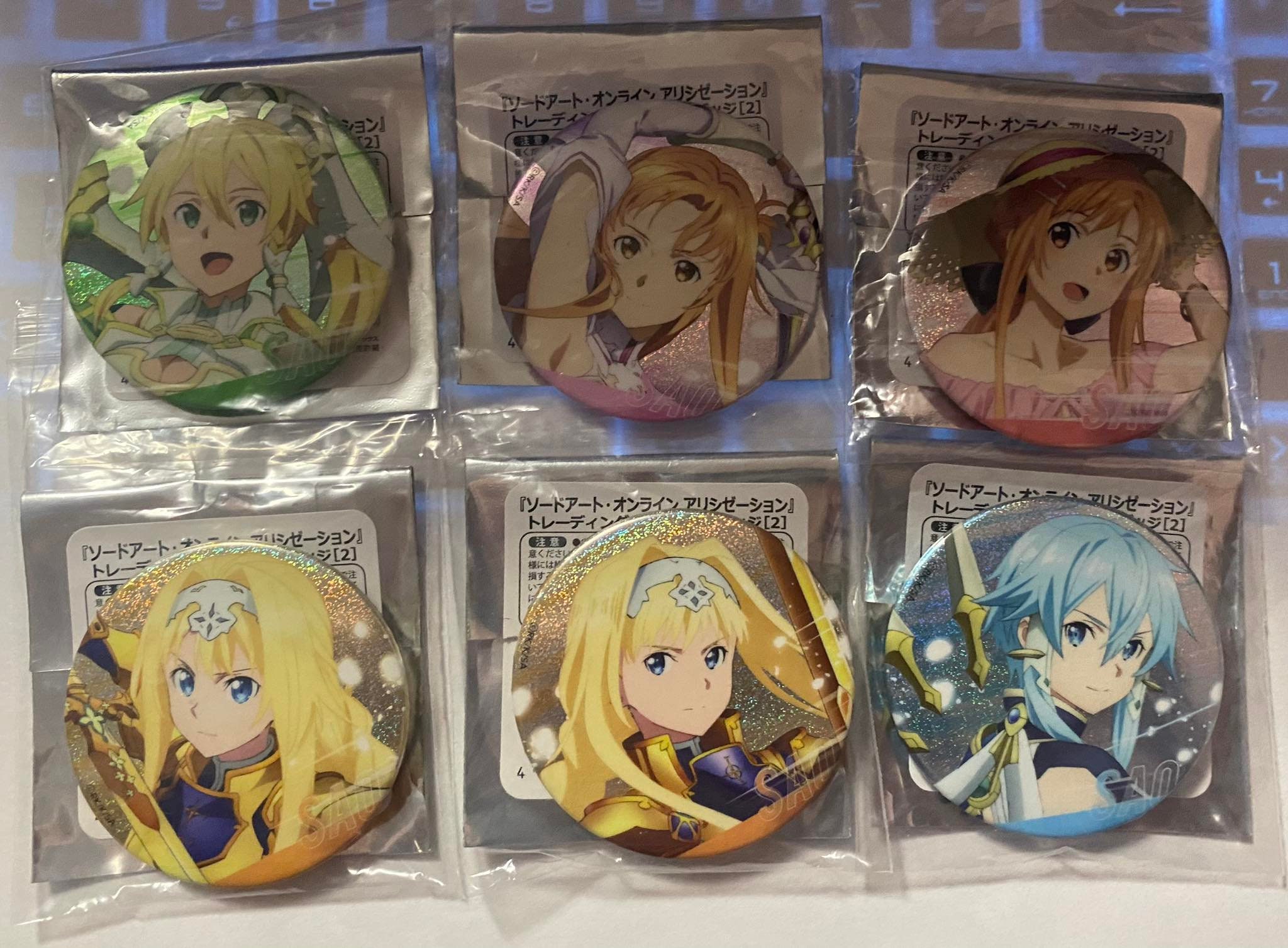 Distintivo di latta glitterato ufficiale Sword Art Online Alicization vol. 1
