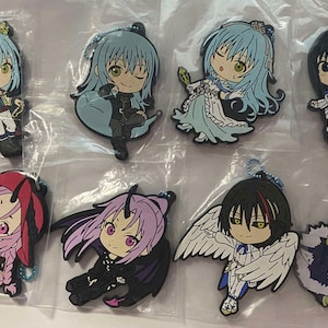 Puede incluir: Una colección de ocho llaveros de personajes de estilo anime. Los llaveros presentan varios personajes con diseños detallados, incluyendo personajes con cabello azul, negro y rosa, alas y atuendos únicos. Cada llavero tiene una cadena de metal.