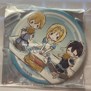May include: A round, light blue button featuring three cartoon characters in a whimsical style. The characters are depicted with blonde and black hair, wearing blue and white outfits, and holding small, round objects. The button is packaged in clear plastic.