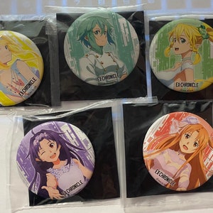 Puede incluir: Cinco botones redondos de personajes de anime. Cada botón presenta un personaje diferente con colores vibrantes y el texto "EX-CHRONICLE". Los botones están empaquetados en plástico transparente.