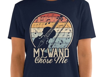 May include: Navy blue t-shirt featuring a vintage-style graphic of a violin and musical notes. The text "My Wand Chose Me" is printed below the graphic.