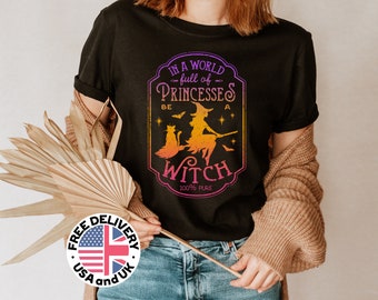 May include: Black t-shirt with a graphic of a witch flying on a broomstick with a cat. The graphic is in a vintage style with a purple, orange, and yellow color scheme. The text on the graphic reads "In a world full of princesses be a witch 100% pure."