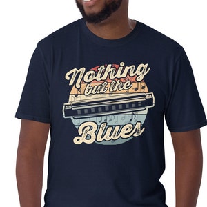 May include: A navy blue t-shirt featuring a vintage-style graphic of a harmonica and the text "Nothing but the Blues".