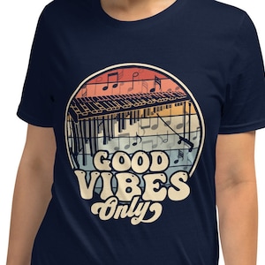 Könnte beinhalten: Marineblaues T-Shirt mit einer Retro-Illustration eines Xylophons mit Noten und dem Text "Good Vibes Only".