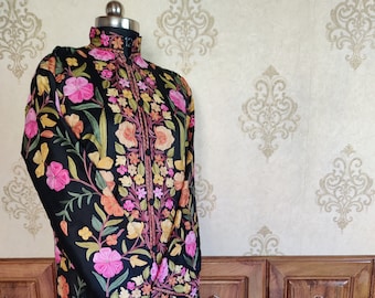May include: A black long-sleeved embroidered robe with a high collar and floral pattern in shades of pink, yellow, and green.