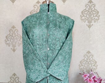 May include: A long, teal blue, button-up jacket with a floral pattern. The jacket has a mandarin collar and long sleeves.
