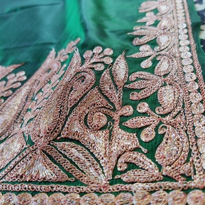 May include: Green fabric with intricate gold and silver embroidery. The embroidery features a floral design with leaves and swirls.