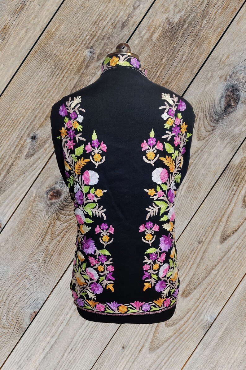 May include: Black shawl with colorful floral embroidery. The embroidery features pink, purple, white, yellow, and green flowers.